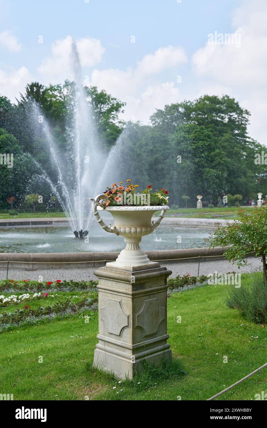 Parc public à Cologne avec un planteur historique et une fontaine en arrière-plan Banque D'Images