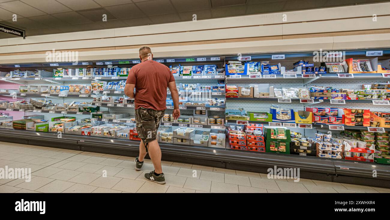 Hambourg, Allemagne. 19 août 2024. Un client fait ses courses dans un supermarché. Crédit : Markus Scholz/dpa/Alamy Live News Banque D'Images