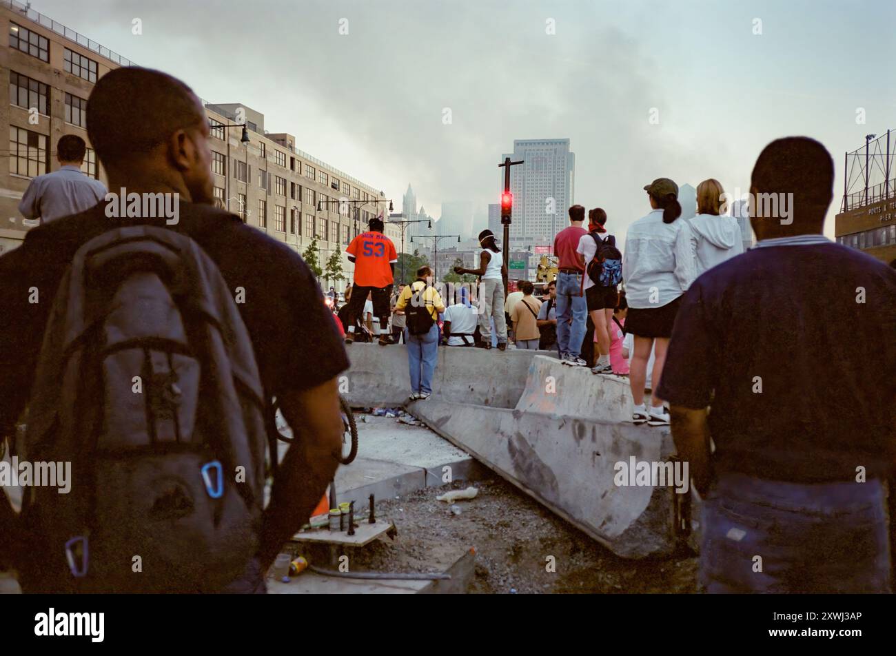 11 septembre 2001 NYC - les foules se rassemblent le long de la West Side Highway en regardant dans un état de choc impuissant. Le 11 septembre 2001, quatre avions commerciaux américains ont été détournés par Al-Qaïda, un groupe terroriste islamiste extrémiste, et ont été armés contre les États-Unis. Tuant près de 3000 personnes et en blessant 6000 autres, ce fut la pire attaque qui ait eu lieu sur le sol des États-Unis. Deux des avions ont été transportés dans le World Trade Center de New York, détruisant les tours jumelles et tuant 2 977 personnes. Ce sont des photos de ce jour et de la semaine à suivre et tournées sur film Banque D'Images