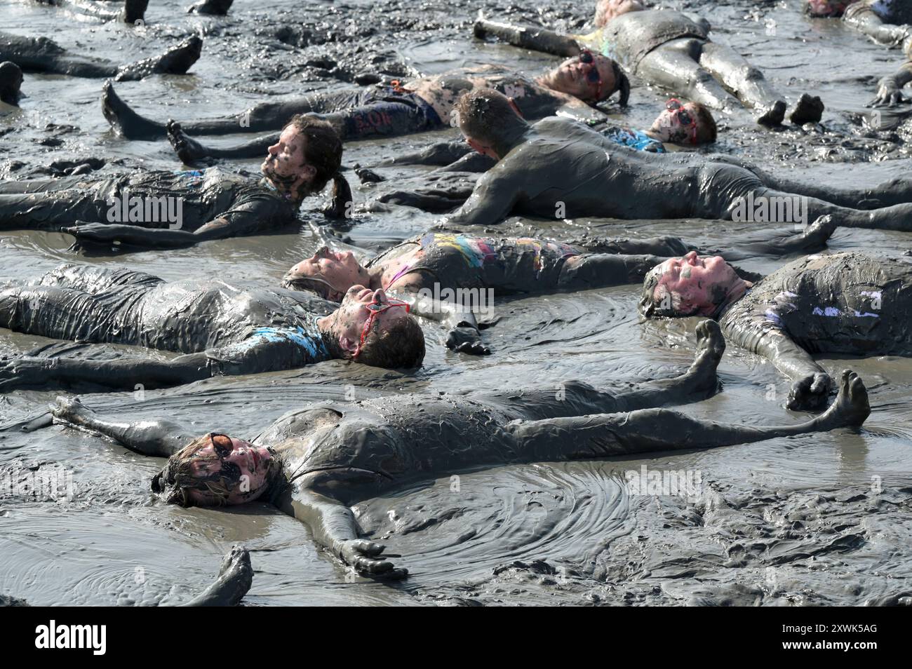 ALLEMAGNE, Schleswig-Holstein, Brunsbuettel, été 2024, festival des Wattolümpiade jeux olympiques de wadden en mer de wadden en mer du Nord allemande, beaucoup de gens ont un bain de wadden dans la boue à marée basse / DEUTSCHLAND, Brunsbüttel, Watt Olümpiade im Wattenmeer, Teilnehmer beim gemeinsamen Schlammbad im Schlick BEI Ebbe Banque D'Images