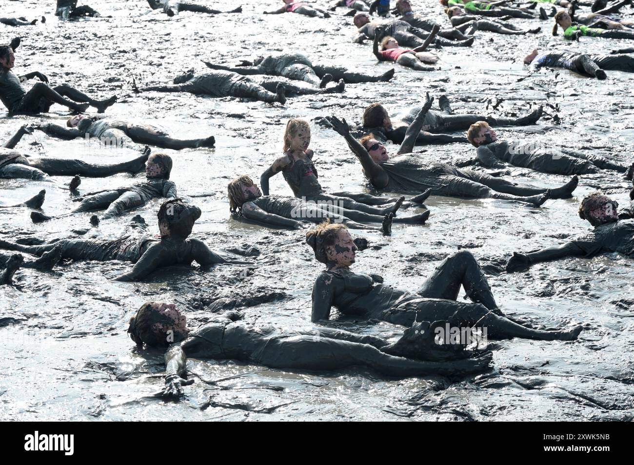 ALLEMAGNE, Schleswig-Holstein, Brunsbuettel, été 2024, festival des Wattolümpiade jeux olympiques de wadden en mer de wadden en mer du Nord allemande, beaucoup de gens ont un bain de wadden dans la boue à marée basse / DEUTSCHLAND, Brunsbüttel, Watt Olümpiade im Wattenmeer, Teilnehmer beim gemeinsamen Schlammbad im Schlick BEI Ebbe Banque D'Images
