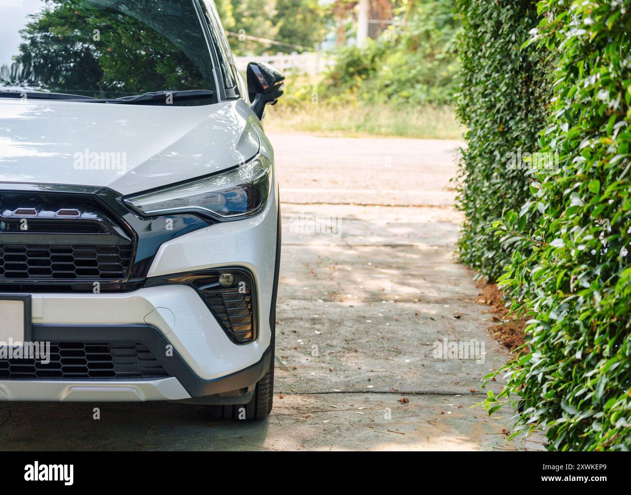 Devant le phare de voiture SUV moderne blanc garé dans le jardin sur la cour Banque D'Images