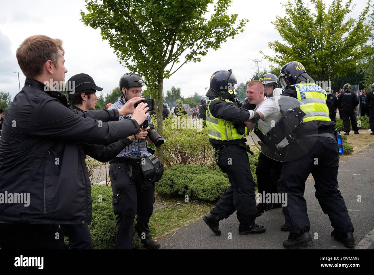 Photo du dossier datée du 04/08/24 des policiers qui détiennent un homme maintenant identifié comme Liam Gray lors d'une manifestation anti-immigration devant le Holiday Inn Express à Rotherham, South Yorkshire. Le jeune homme de 20 ans a été emprisonné pendant trois ans à la cour de la Couronne de Sheffield après avoir été capturé sur vidéo en train de charger à plusieurs reprises devant une ligne de police avec des boucliers anti-émeute devant l'hôtel abritant des demandeurs d'asile. Date d'émission : dimanche 4 août 2024. Banque D'Images