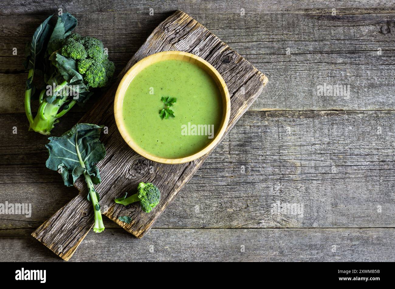 Soupe fraîche de brocoli dans un bol en bois sur une table sombre, concept alimentaire de détox diététique, vue de dessus Banque D'Images
