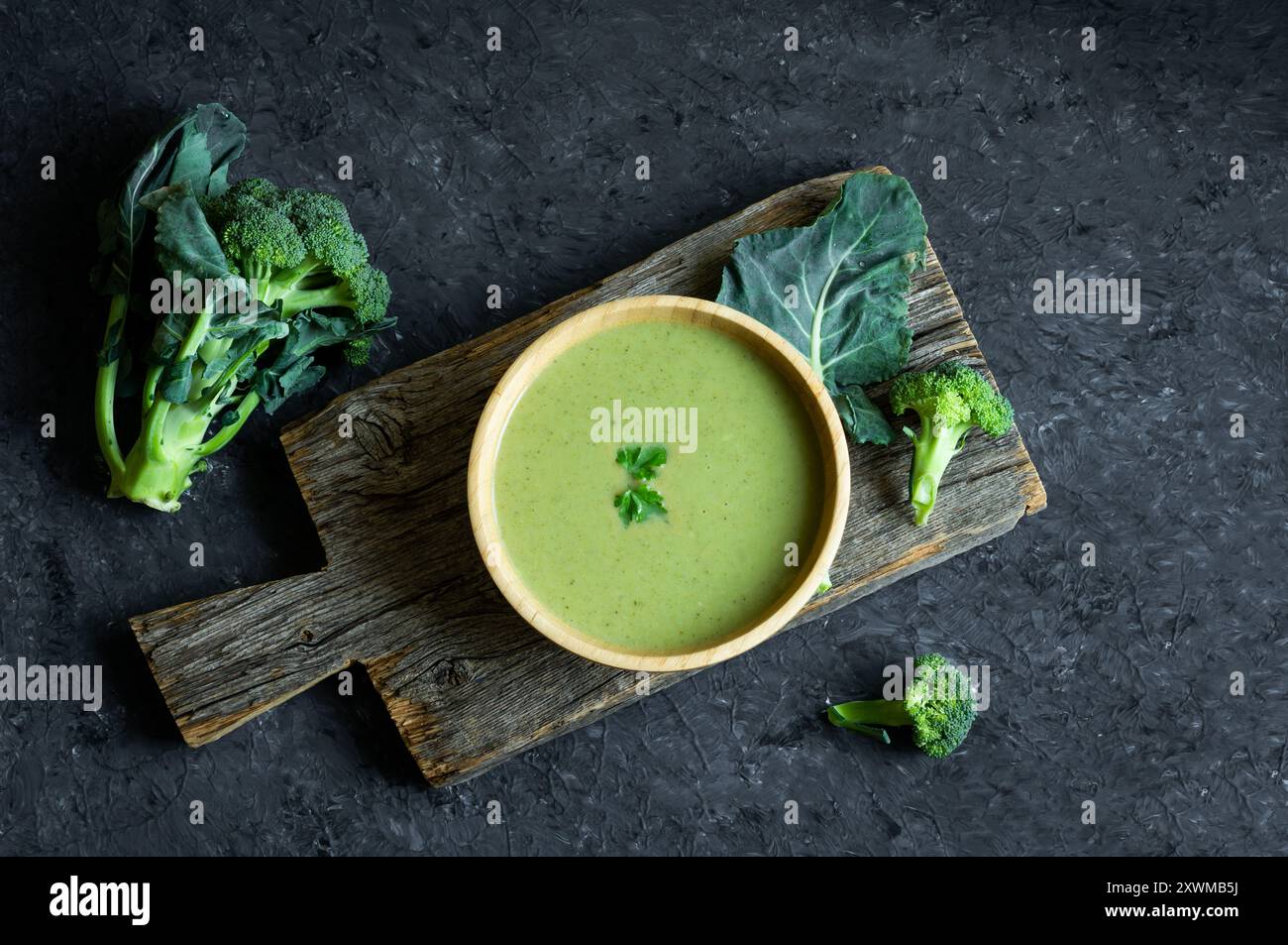 Soupe fraîche de brocoli dans un bol en bois sur une table sombre, concept alimentaire de détox diététique, vue de dessus Banque D'Images