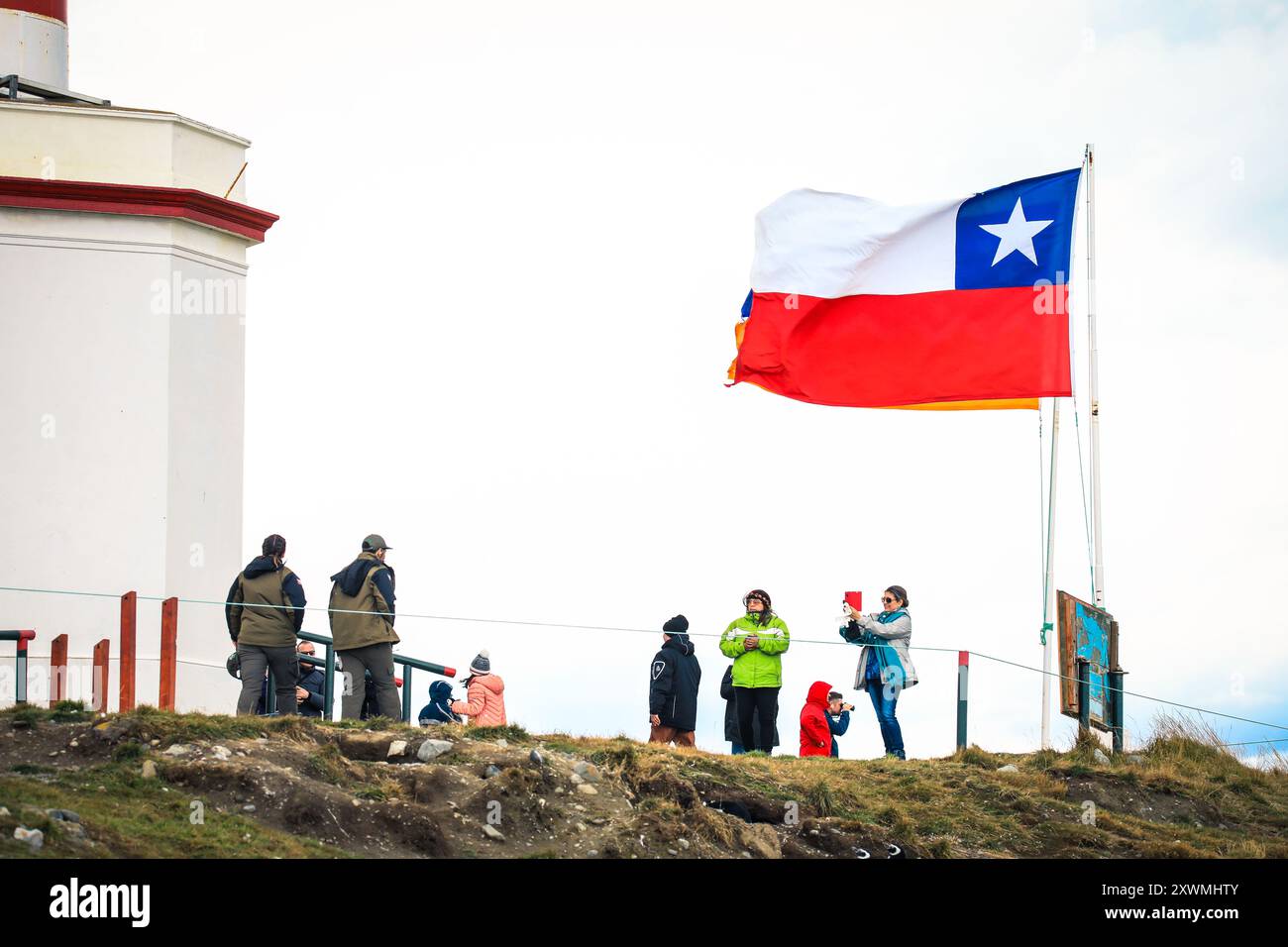 Femme touriste dans la veste rouge sur l'île de Magdalena faisant les photos de manchots Magellanic près de Punta Arenas, Chili Banque D'Images