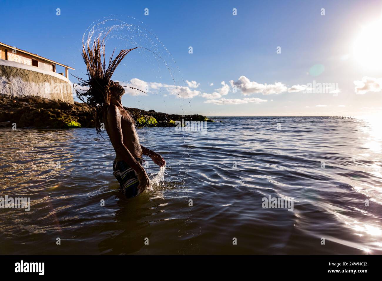 Homem tomando banho na praia do Rio Vermelho na Bahia Banque D'Images