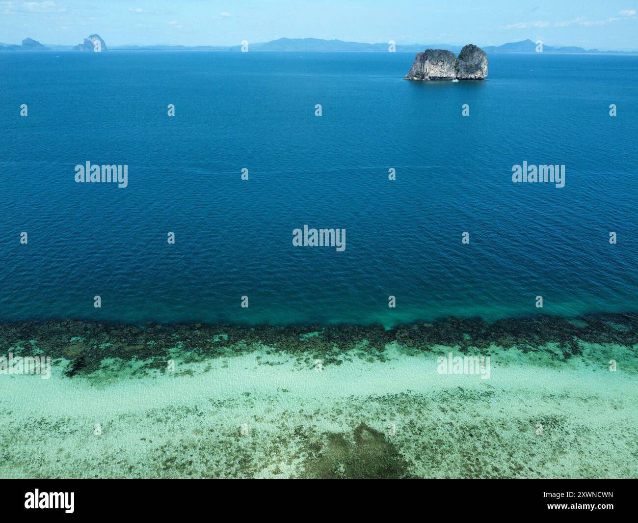Photo aérienne de Ko Ngai dans l'après-midi avec vue sur le récif corallien, la falaise sous-marine et l'océan bleu marine et Ko Maa en arrière-plan Banque D'Images