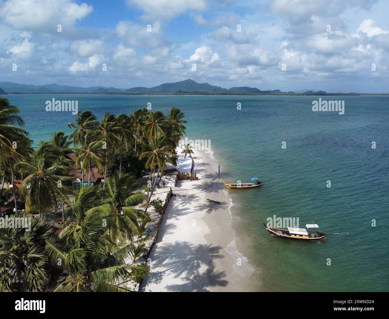 Vue aérienne de la Pearl Beach à Ko Muk avec des bateaux à longue queue, des palmiers et Trang en arrière-plan Banque D'Images
