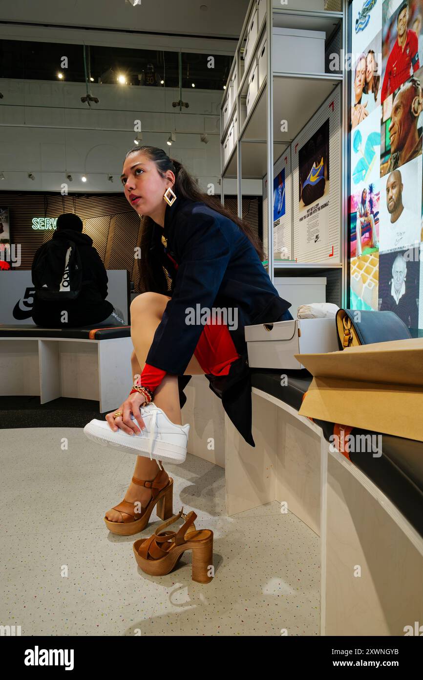 Londres - 06 11 2022 : Sitting Girl essaie une paire de chaussures Banque D'Images