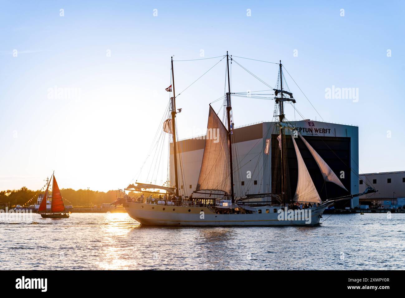 Segelschiff fährt an der Neptun Werft während der Hansesail 2024 vorbei, 10.08.2024, Werfthalle am Abend Neptunwerft à Rostock-Warnemünde *** voilier passe devant le chantier naval de Neptun pendant le Hansesail 2024, 10 08 2024, hall du chantier naval dans la soirée chantier naval de Neptun à Rostock Warnemünde 20240810-DSC 4132 Banque D'Images