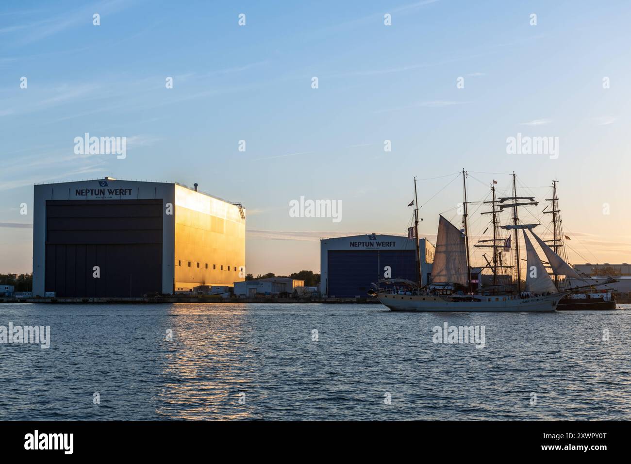 Segelschiff fährt an der Neptun Werft während der Hansesail 2024 vorbei, 10.08.2024, Werfthalle am Abend Neptunwerft à Rostock-Warnemünde *** voilier passe devant le chantier naval de Neptun pendant le Hansesail 2024, 10 08 2024, hall du chantier naval dans la soirée chantier naval de Neptun à Rostock Warnemünde 20240810-DSC 4136 Banque D'Images