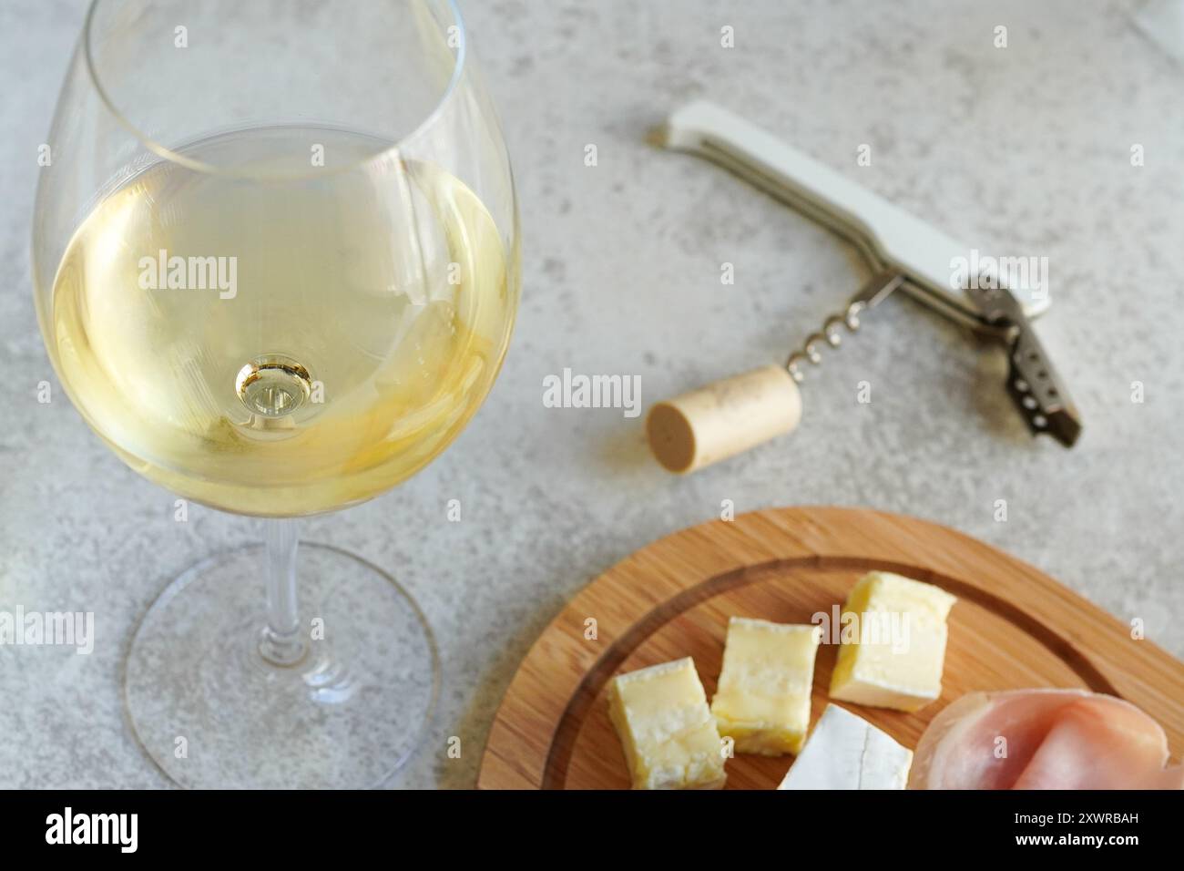 Un verre de vin blanc froid et assortiment de fromages pour les hors-d'œuvre Banque D'Images