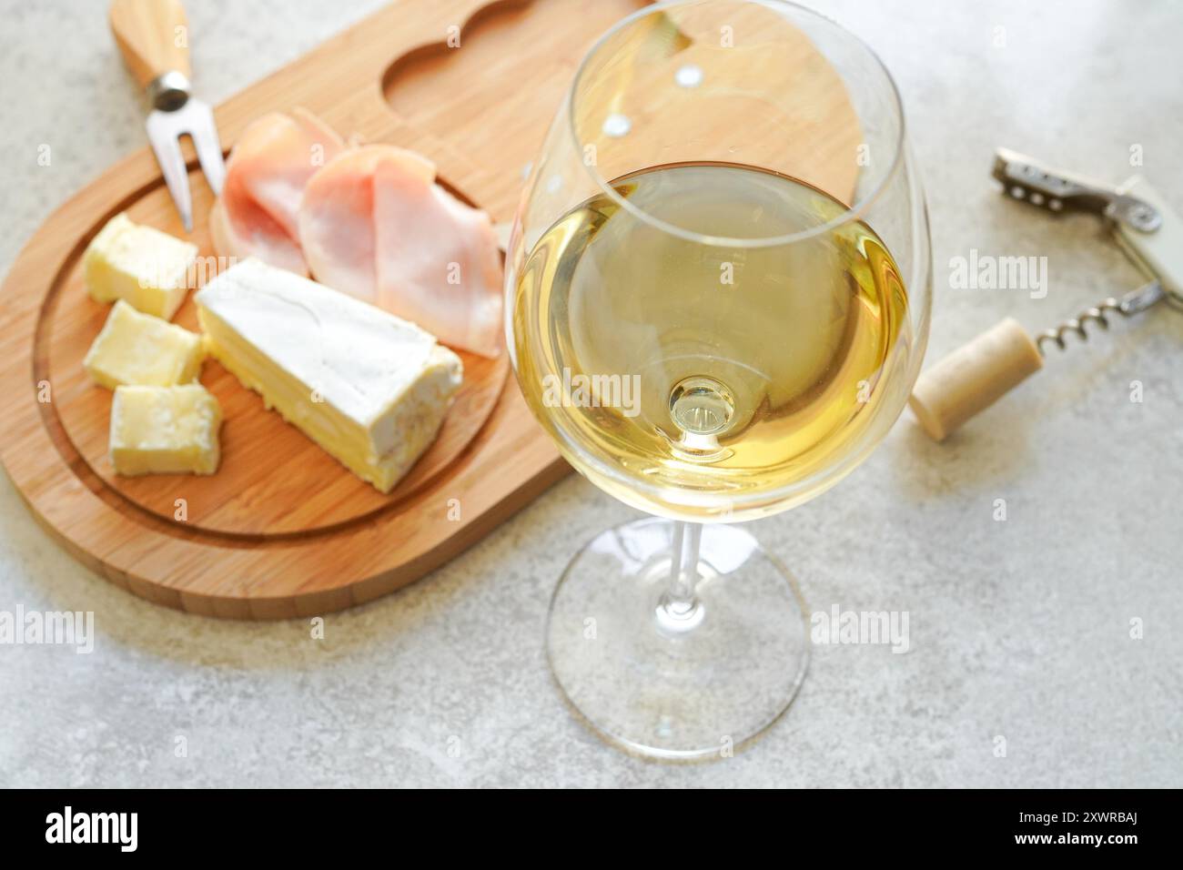 Un verre de vin blanc froid et assortiment de fromages pour les hors-d'œuvre Banque D'Images