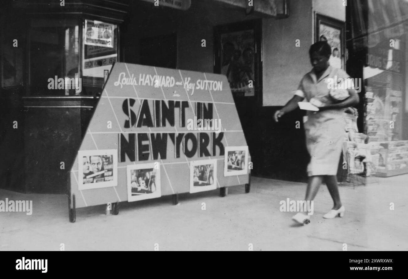 Une femme afro-américaine passe devant un écran publicitaire pour le film 'Saint in New York' devant le Lyric Theater à Odessa, Texas en 1938. Banque D'Images