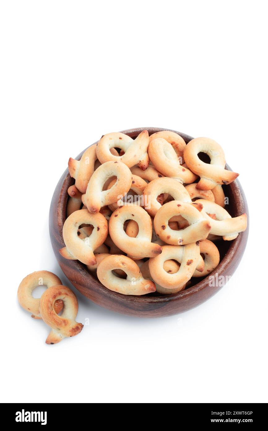 Taralli italien avec oignon dans la boulette de bois isolé sur blanc Banque D'Images