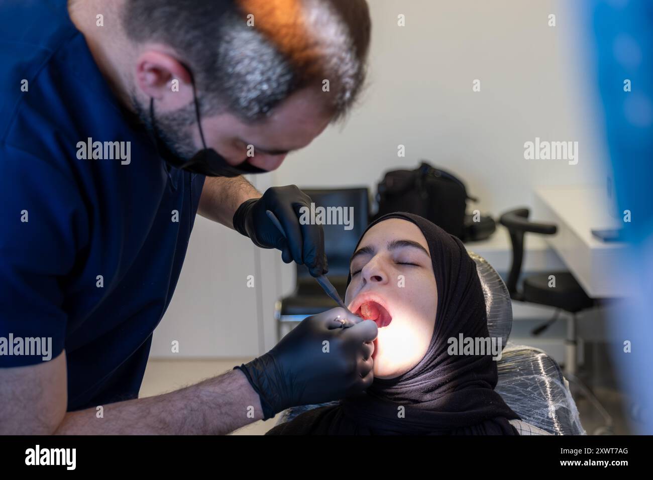 une femme musulmane sur un fauteuil dentiste a besoin d'un traitement pour son mal de dents Banque D'Images