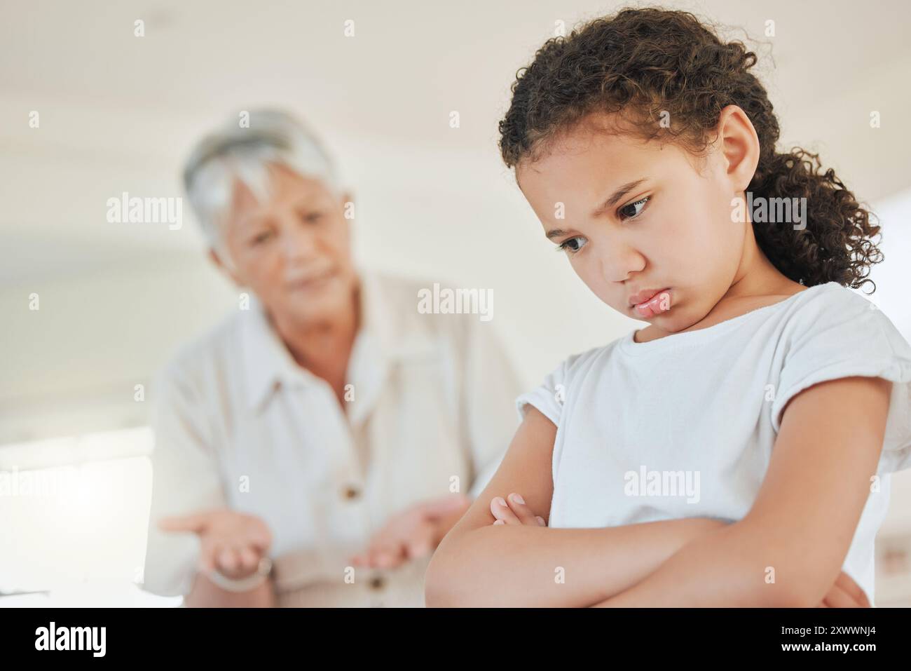 Grand-mère senior, agacée et fille à la maison avec leçon, en colère et discipline pour le comportement au Mexique. Personne âgée, femme et grondement à l'enfant avec Banque D'Images