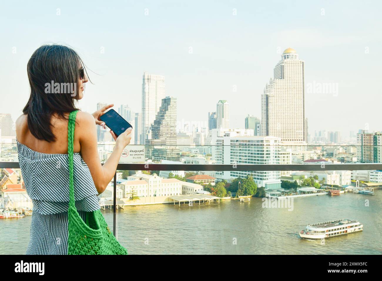 Jeune jolie femme touriste profitant de Bangkok paysage urbain skyline prendre la vidéo. Célèbre centre commercial au-dessus du quai d'observation de la ville. Femme blogueuse Trav Banque D'Images