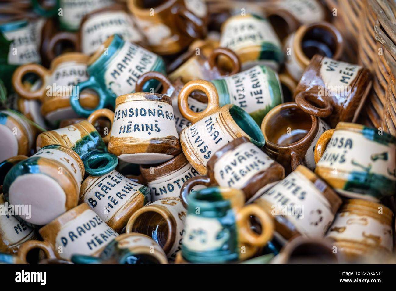 Jaunpils, Lettonie - 10 août 2024 : une collection de tasses en céramique avec des étiquettes manuscrites uniques. Banque D'Images