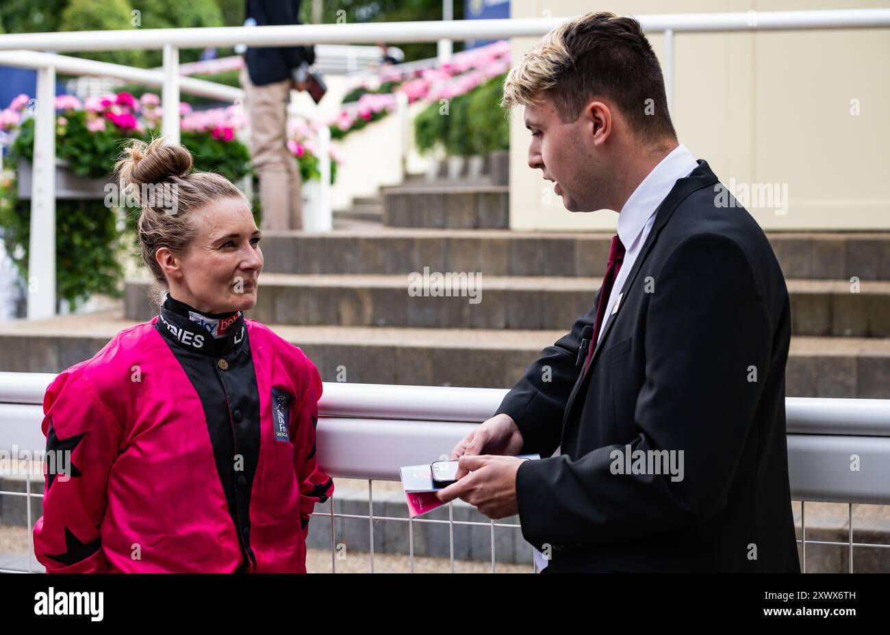 Luca Viscogliosi, présentateur de course, interviewe la jockey Joanna Mason à l’hippodrome d’Ascot le jour de la Coupe Shergar, le 10/08/2024. Crédit JTW Equine images / Alamy. Banque D'Images