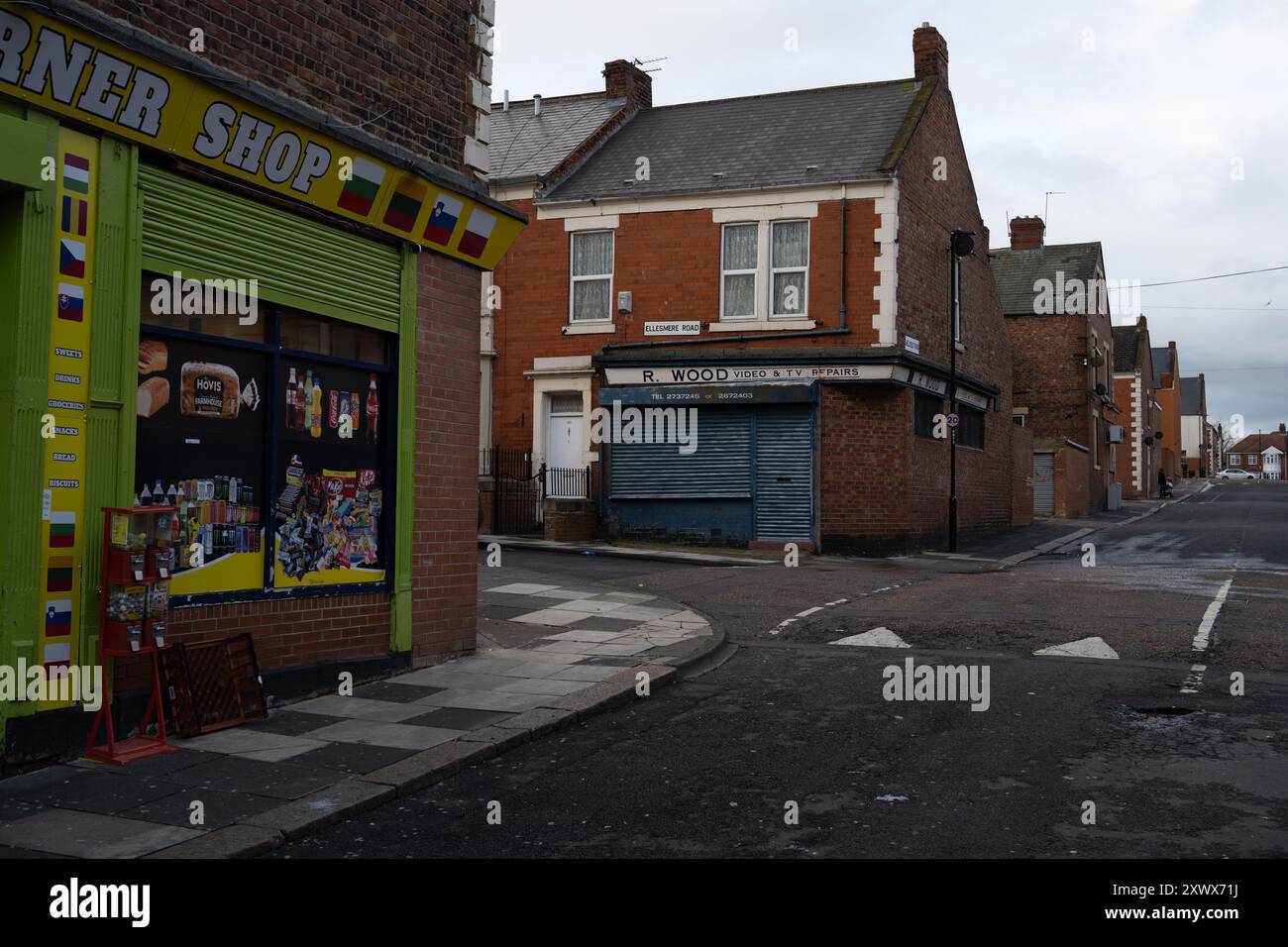 Vue sur la rue de Fenham, Newcastle upon Tyne, avec un magasin du coin et un magasin de réparation de téléviseurs fermé. L'image capture l'essence de la vie quotidienne dans un quartier résidentiel, offrant une métaphore pour les temps changeants. Banque D'Images