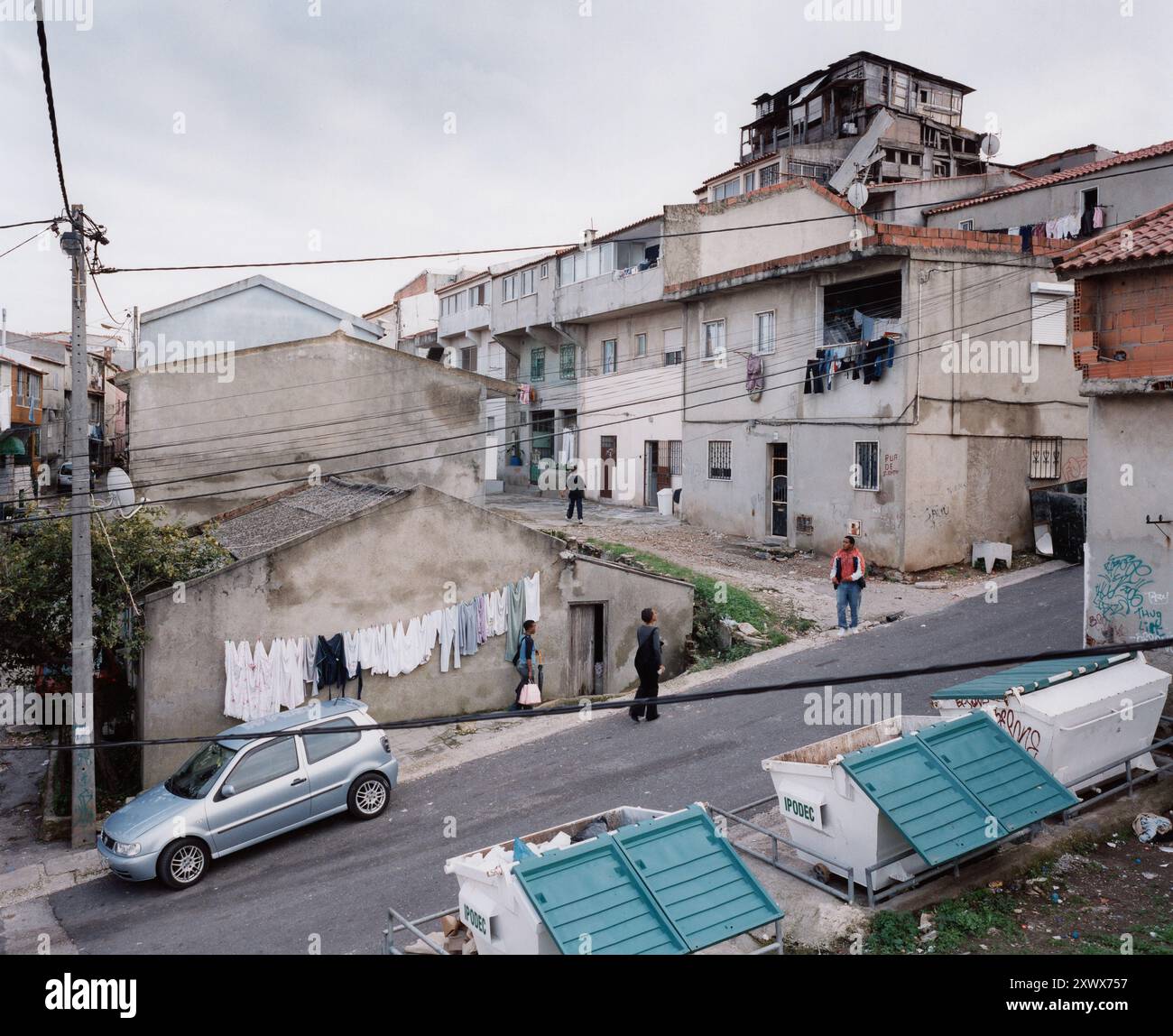 Vue du quartier de Couva da Moura à Lisbonne, Portugal. Les résidents marchent le long de la rue et le linge traîne pour sécher. La région a un mélange de maisons et de signes visibles de subsistance, avec un sentiment de communauté. 2006 Banque D'Images