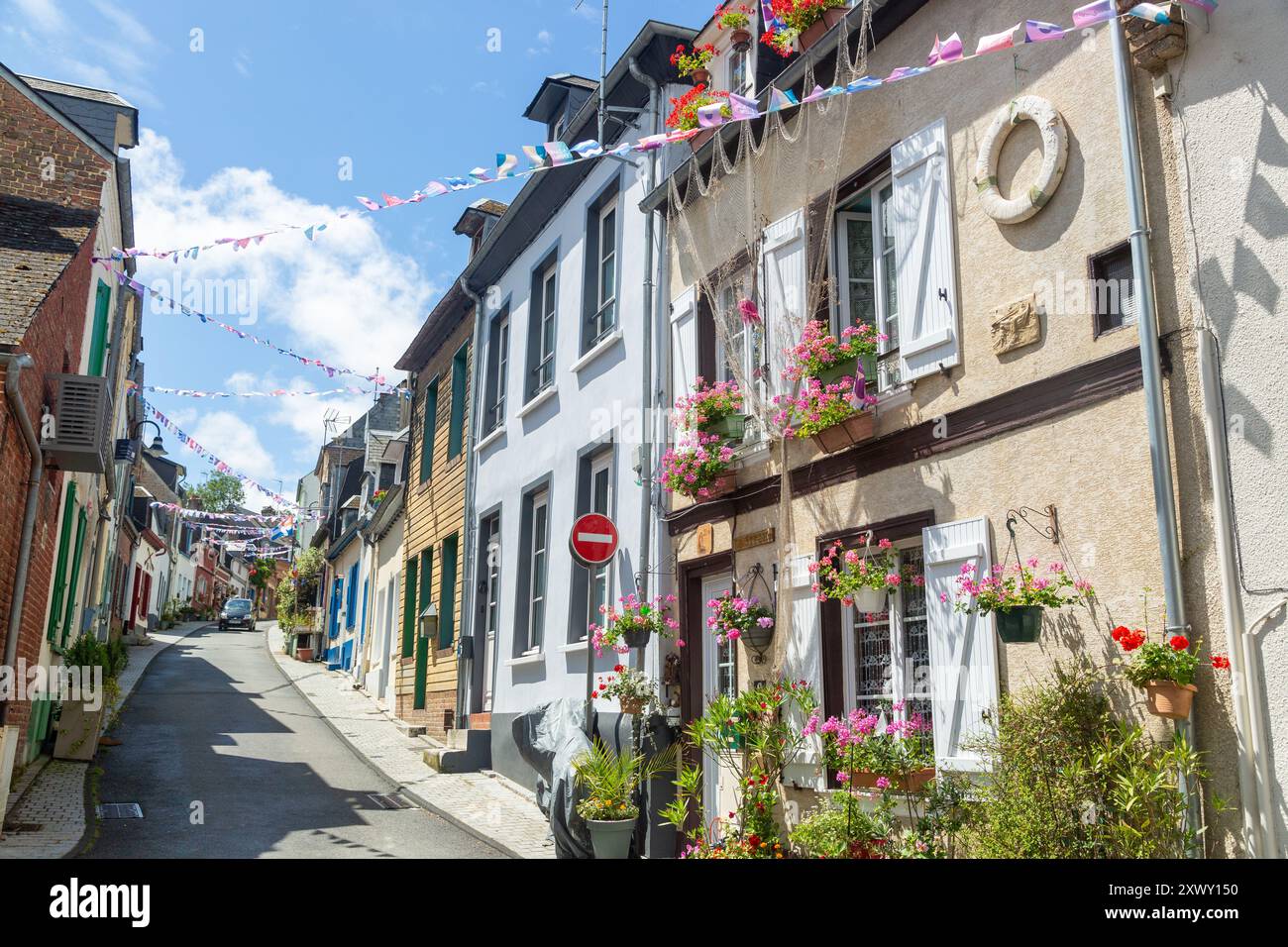 Fleurs lumineuses à l'extérieur de vieilles maisons traditionnelles dans la rue des Moulins, St Valery sur somme, somme, Picardie, France Banque D'Images