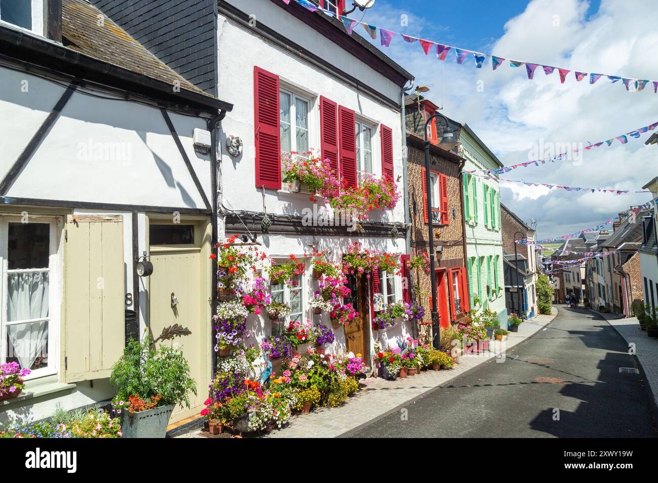 Fleurs lumineuses à l'extérieur de vieilles maisons traditionnelles dans la rue des Moulins, St Valery sur somme, somme, Picardie, France Banque D'Images