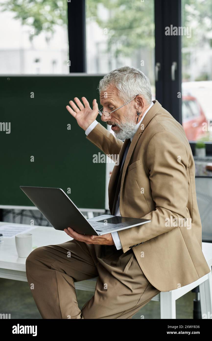 Un professeur barbu, vêtu d'un costume, enseigne passionnément en ligne via son ordinateur portable, captivant ses étudiants. Banque D'Images