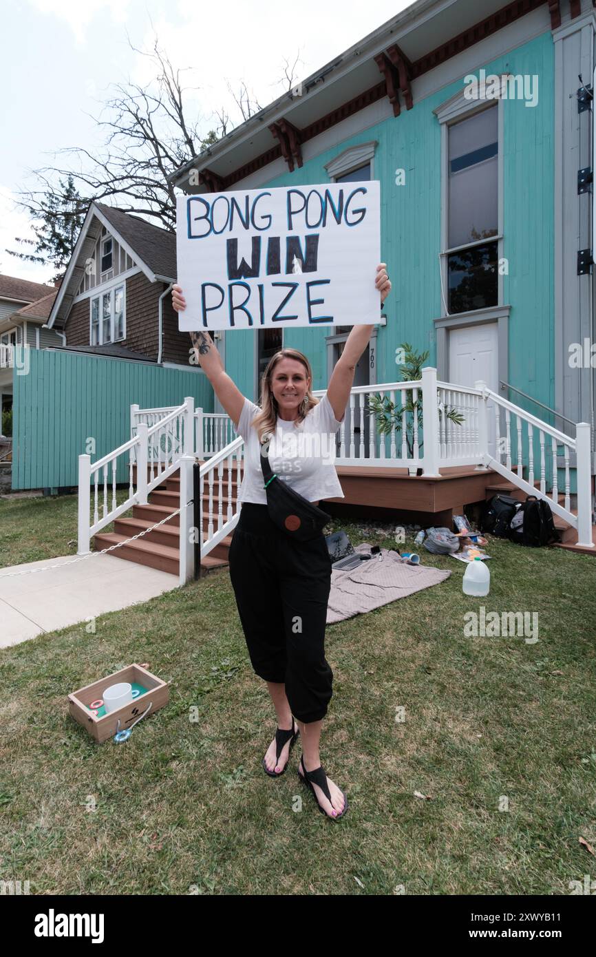 Femme tenant une pancarte lisant le prix Bong Pong Win, devant un dispensaire légal de marijuana à Ann Arbor Michigan USA Banque D'Images