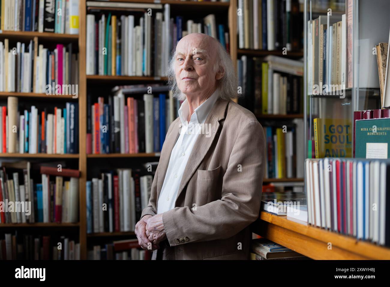 Cologne, Allemagne. 21 août 2024. Le libraire d'antiquaires Klaus Willbrand figure parmi les livres de sa librairie d'occasion à Sülz. À 83 ans, Willbrand est devenue une star TikTok et Instagram. Crédit : Rolf Vennenbernd/dpa/Alamy Live News Banque D'Images