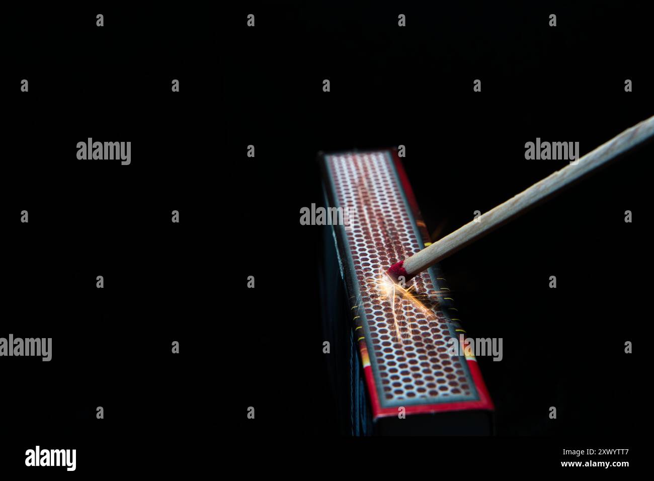 L'allumette frotte contre la surface de frottement de la boîte d'allumettes et des étincelles sont produites Banque D'Images