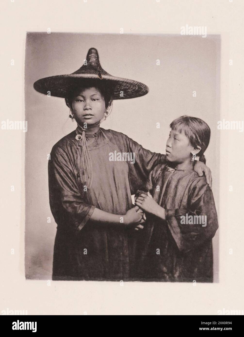 Photo vintage de Canton Boat-girls en robe chinoise traditionnelle. Illustrations de la Chine du XIXe siècle, 1875. Ce sont les deux filles d'une famille respectable de plaisanciers. Ils ont été traités à l'utilisation de l'aviron, et à la gestion des bateaux, dès la plus tendre enfance. Heureux pour eux, ils ne sont pas des esclaves, achetés par une dame dessinatrice, et destinés à un sort pire que la vie de l'industrie prudente commune aux travailleurs pauvres de Canton. Les filles, habillées avec une simplicité modeste, pondent leurs cheveux noirs brillants avec une fleur de couleur vive qui rehausse l'effet de leurs yeux sombres Banque D'Images