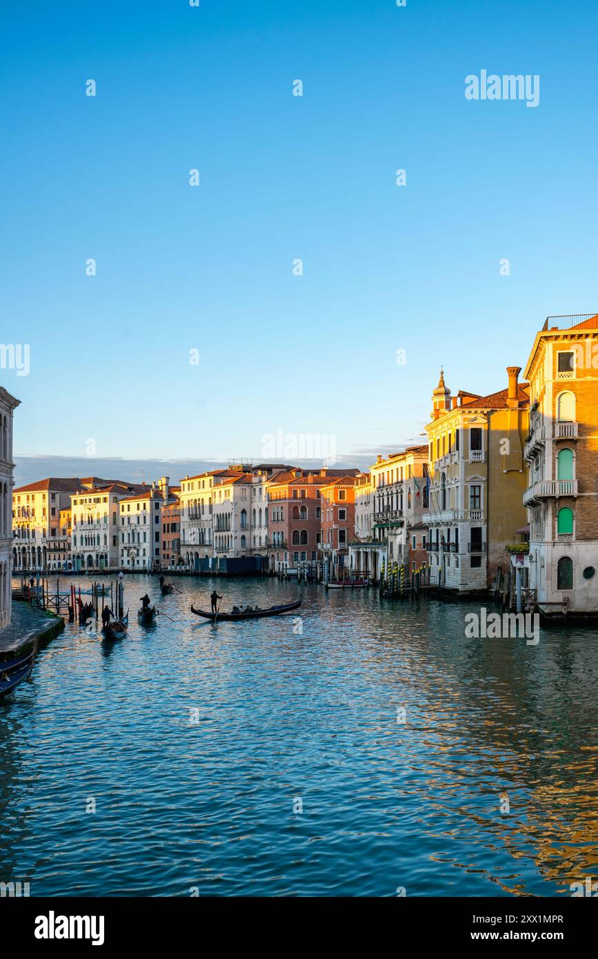 Vue avec des maisons colorées et Camerlenghi Palace vu de l'autre côté du Grand canal avec des gondoles traditionnelles au coucher du soleil, Venise, Vénétie Banque D'Images