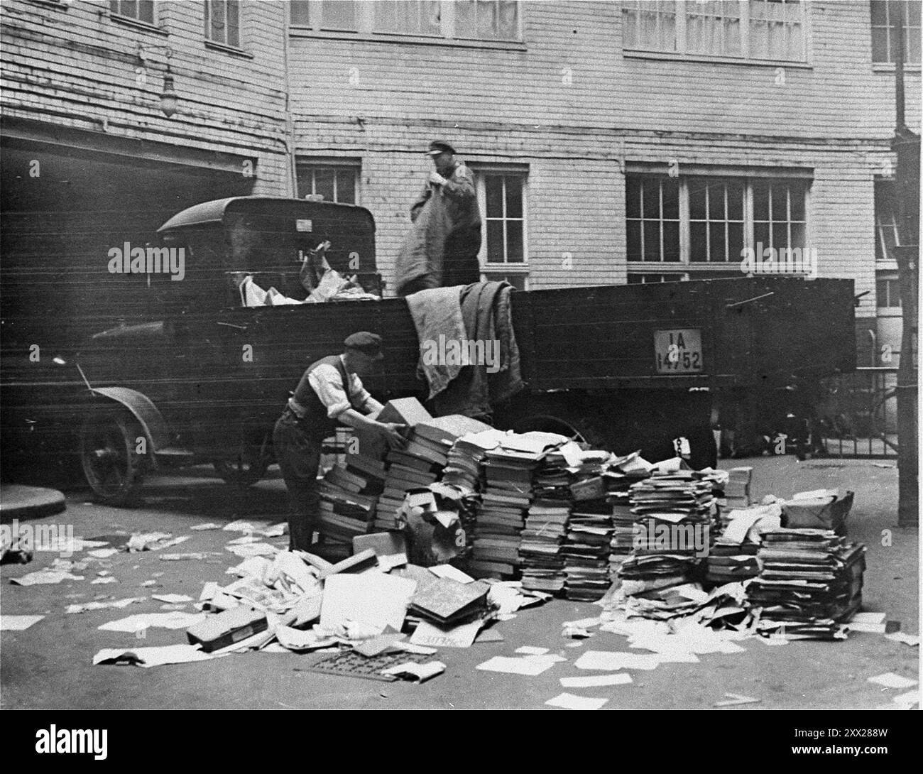 Des civils aident à charger des publications communistes à l'arrière d'un camion lors d'un raid dans la maison Karl-Liebknecht (quartier général du KPD) à Berlin. Après que Hitler eut reçu le pouvoir, il se déplaça rapidement et efficacement pour le garder. Après l'incendie du Reichstag, les communistes ont été blâmés (qui a effectivement mis le feu est encore dans le doute). Après une campagne anti-comuniste frénétique, ils ont été déclarés illégaux, les membres ont été emprisonnés, leurs bureaux ont été saccagés et toute la littérature détruite. Avec l'opposition affective ainsi éliminée, les nazis remportèrent facilement les élections générales un mois plus tard. Banque D'Images