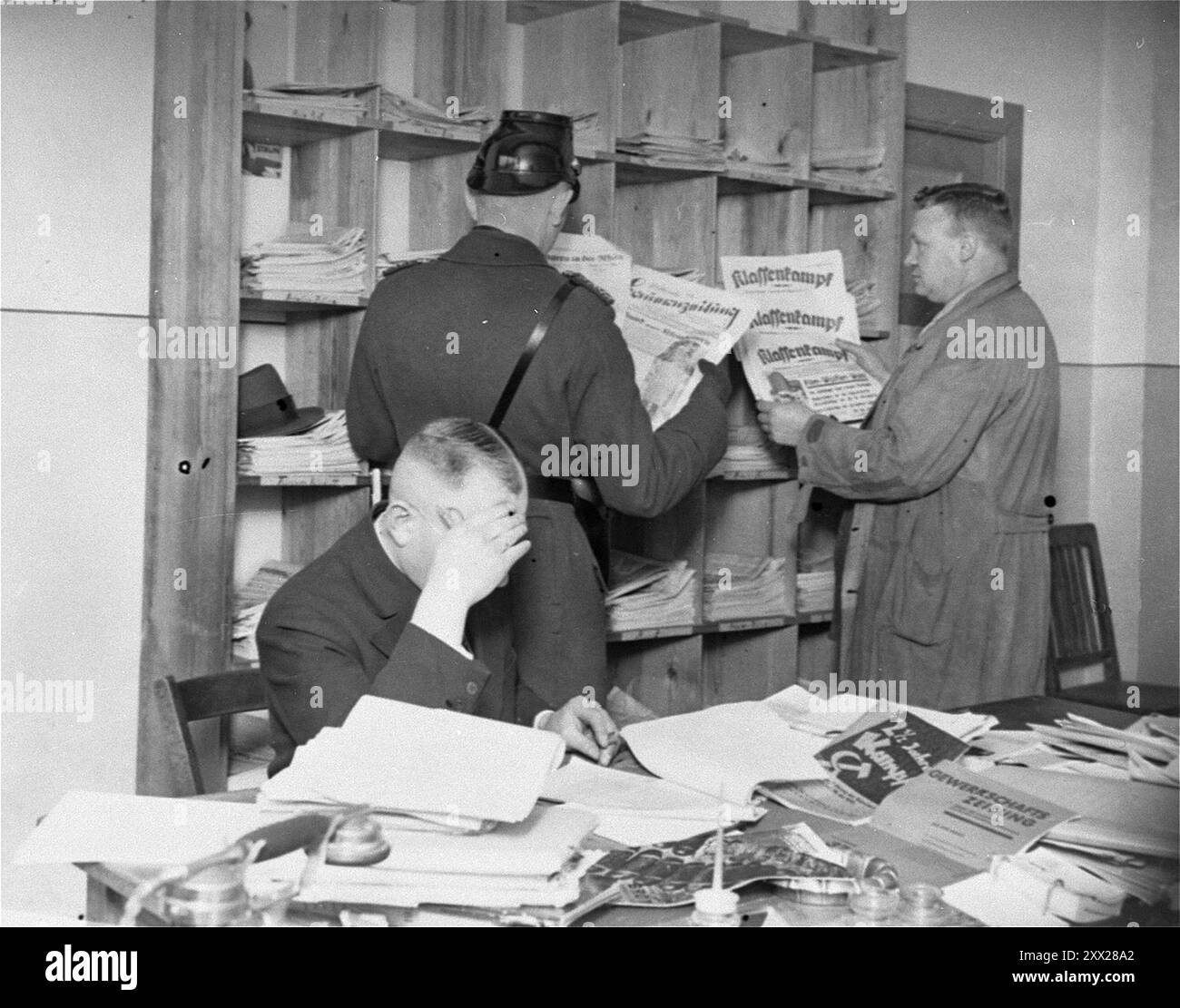 Les officiers de la Gestapo et les Schutzpolizei examinent les journaux et les publications lors de la fermeture de la maison Karl-Liebknecht (siège du KPD) sur le Bülowplatz à Berlin. Après que Hitler eut reçu le pouvoir, il se déplaça rapidement et efficacement pour le garder. Après l'incendie du Reichstag, les communistes ont été blâmés (qui a effectivement mis le feu est encore dans le doute). Après une campagne anti-comuniste frénétique, ils ont été déclarés illégaux, les membres ont été emprisonnés, leurs bureaux ont été saccagés et toute la littérature détruite. Avec l'opposition affective ainsi éliminée, les nazis remportèrent facilement les élections générales un mois plus tard. Banque D'Images