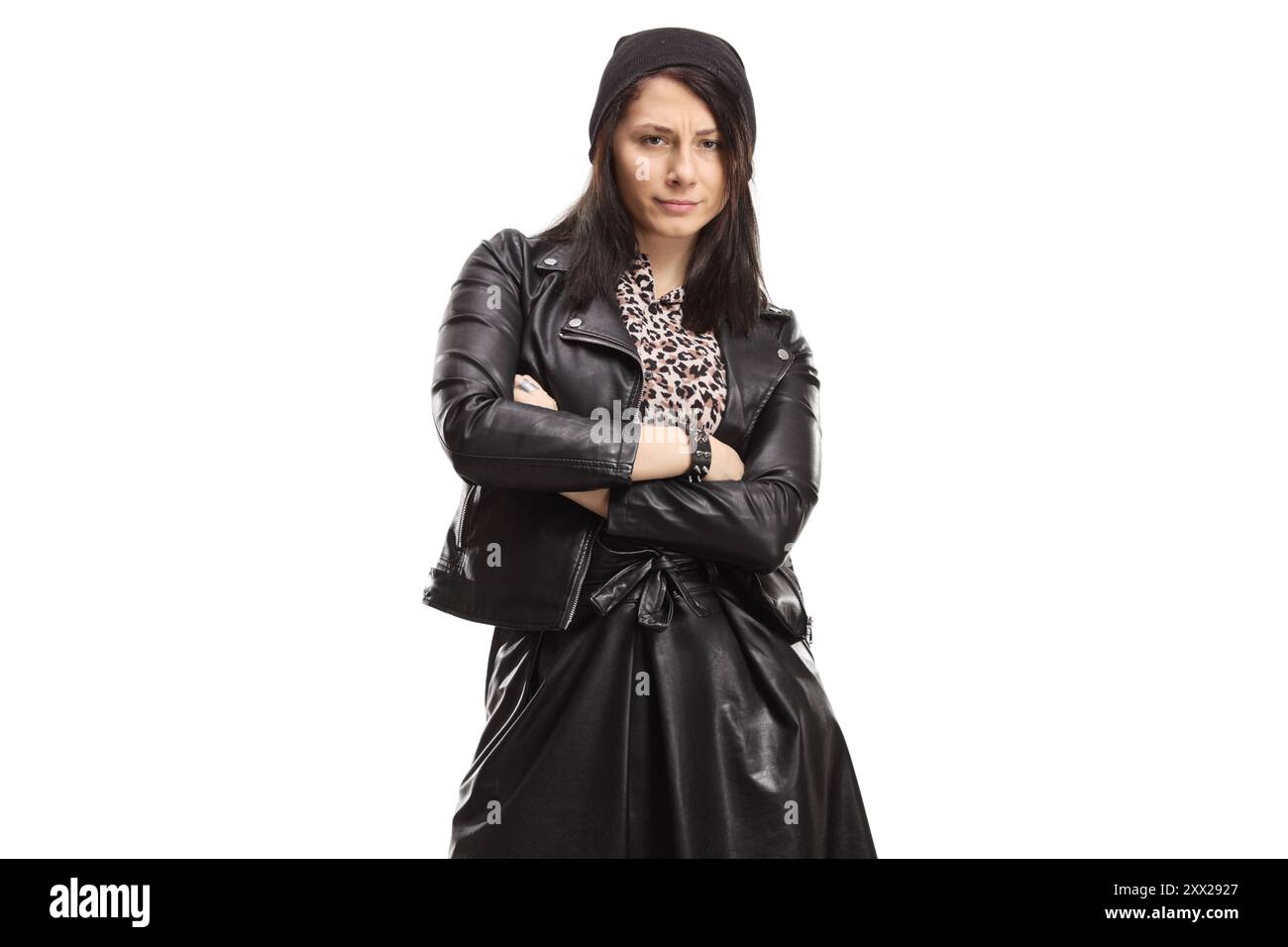 Jeune femme en veste en cuir noir et jupe posant avec les bras croisés isolé sur fond blanc Banque D'Images