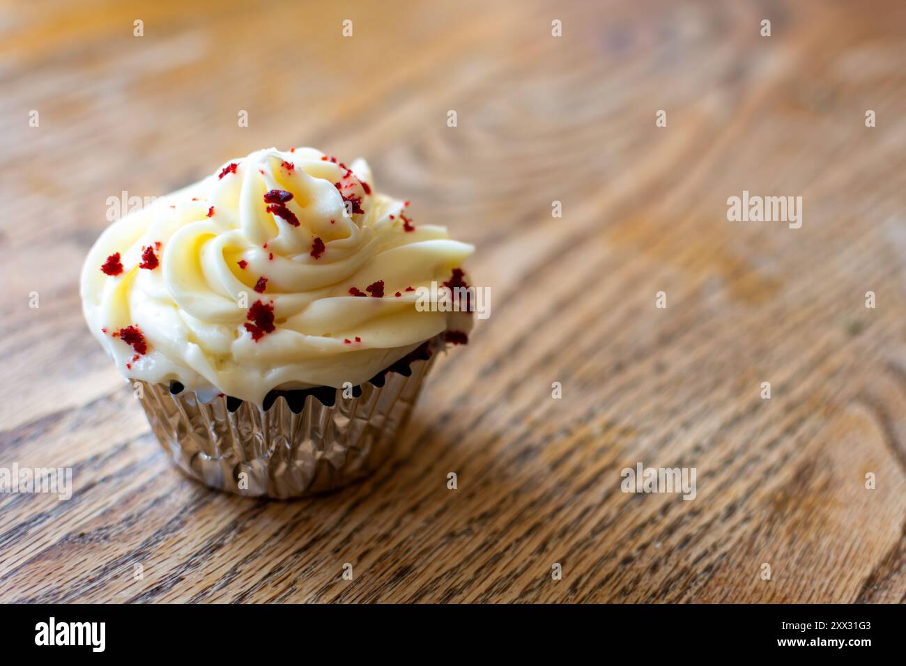 Un cupcake en velours rouge sur une table en bois avec espace copie. Banque D'Images