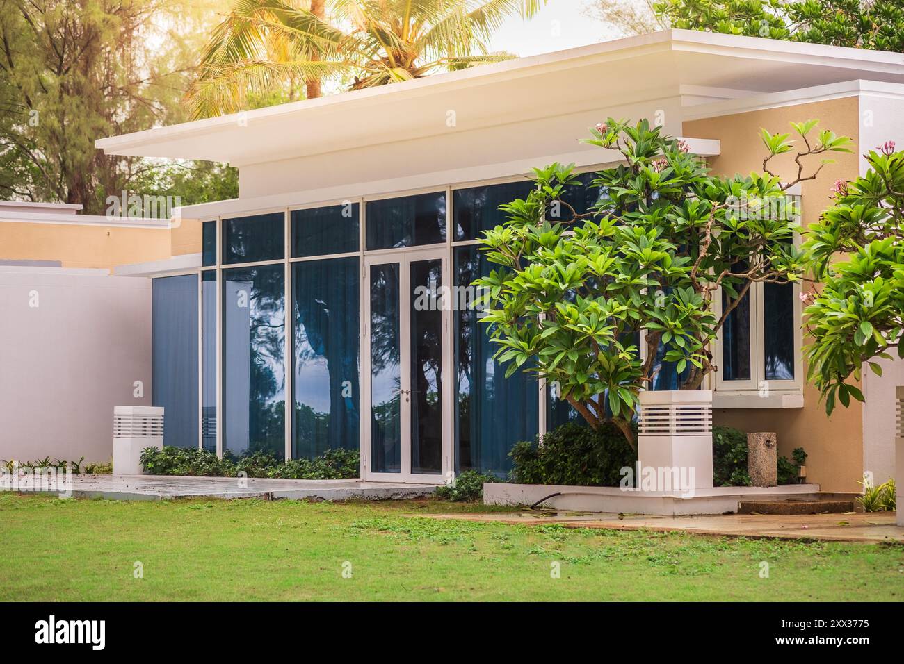 Nouveaux immeubles d'appartements blancs avec fenêtres en verre à Phuket Thaïlande. Architecture résidentielle moderne avec arbres verts et herbe verte. Personne, s Banque D'Images