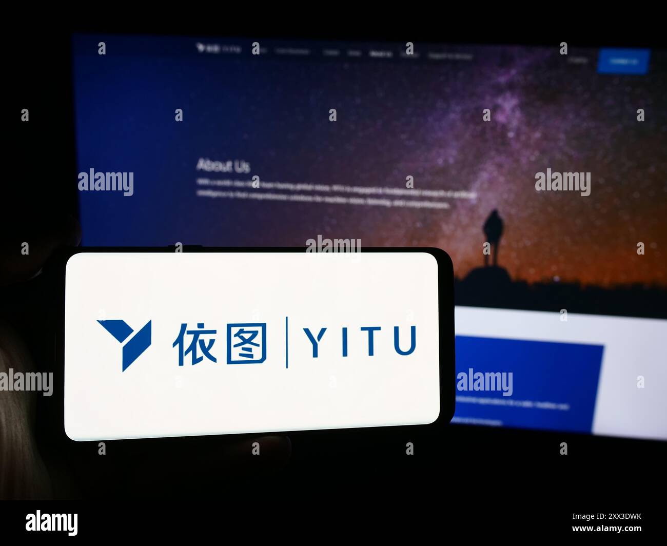 Personne tenant un smartphone avec le logo de la société chinoise ai Shanghai YITU Technology Co. Ltd en face du site Web. Concentrez-vous sur l'affichage du téléphone. Banque D'Images