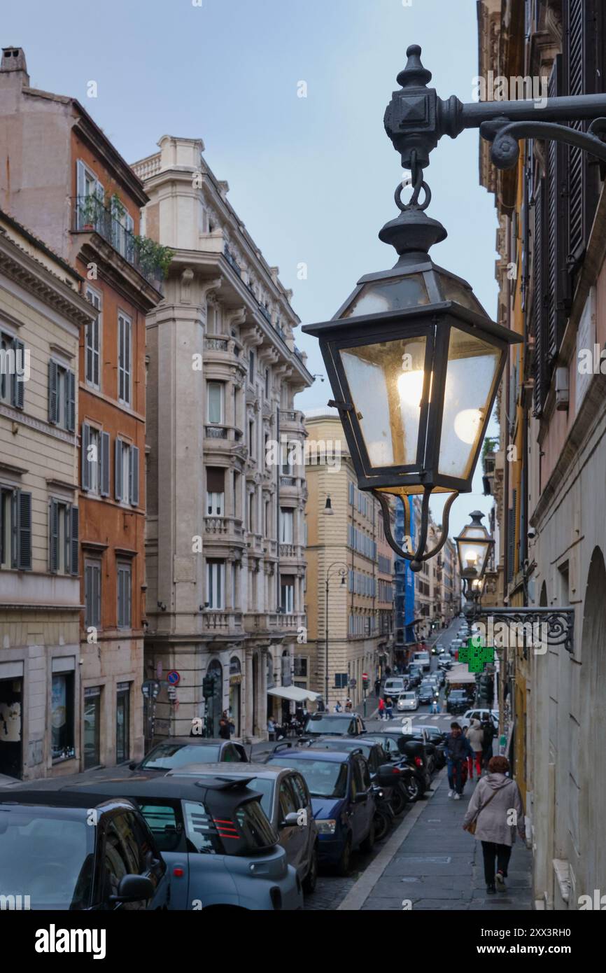 Charmante scène de rue à Rome, Italie, avec des lanternes vintage illuminant une rue italienne classique. Capturer l'essence de la vie quotidienne Banque D'Images