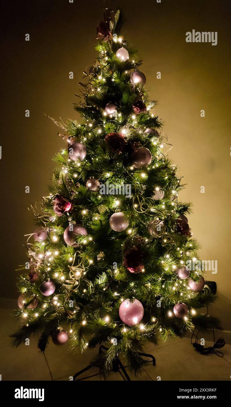 Sapin de Noël illuminé et décoré de couleurs roses Banque D'Images