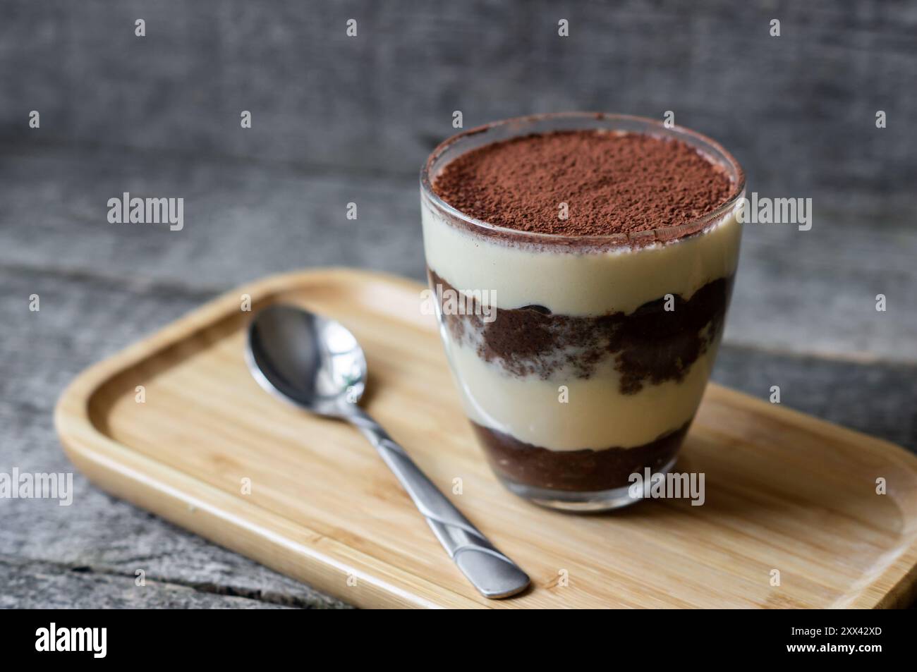 Tiramisu, dessert italien traditionnel en verre sur fond de bois. Mise au point sélective Banque D'Images