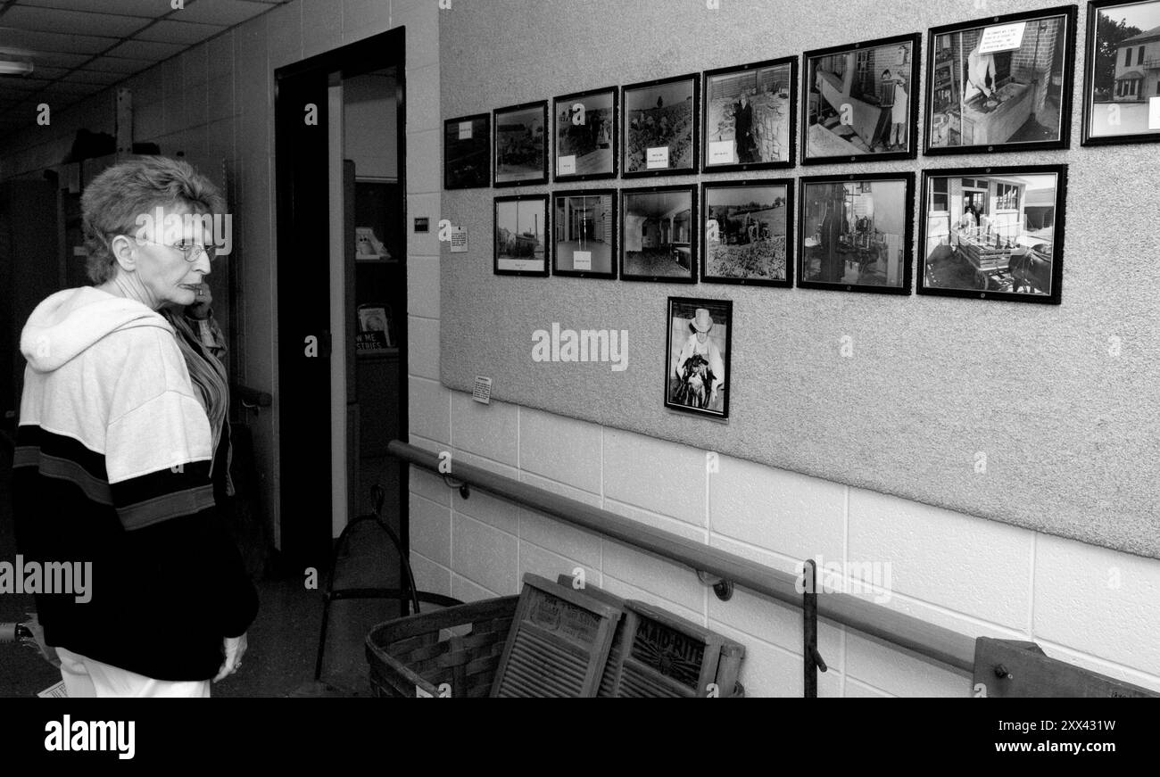 Touriste caucasienne (55-60) regardant de vieilles photos sur le mur au Glore Psychiatric Museum à St Joseph Missouri. ÉTATS-UNIS Banque D'Images