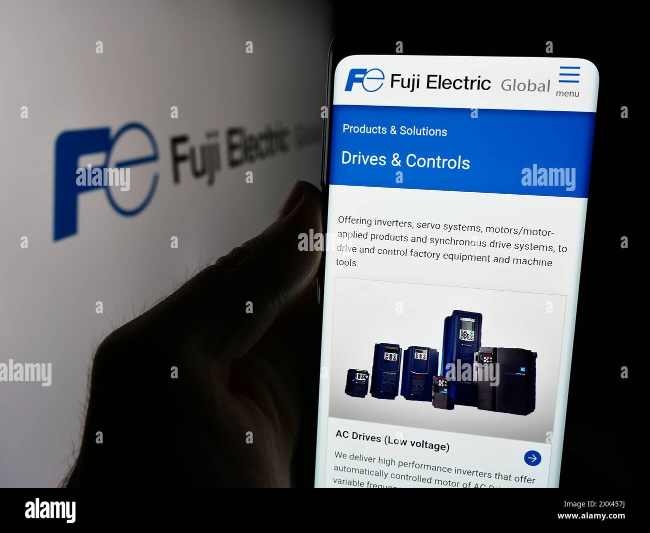 Personne tenant le téléphone portable avec la page Web de la société japonaise Fuji Electric Co. Ltd devant le logo de l'entreprise. Concentrez-vous sur le centre de l'écran du téléphone. Banque D'Images