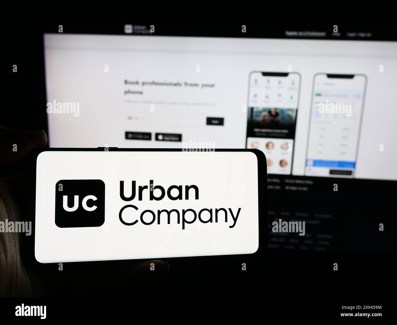 Personne tenant un smartphone avec le logo de la société indienne de marché de services à domicile Urban Company en face du site Web. Concentrez-vous sur l'affichage du téléphone. Banque D'Images