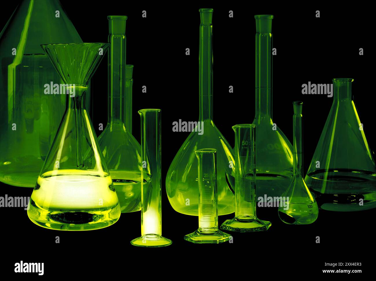 Variété de verrerie de laboratoire partiellement remplie lumineuse et éclatante à dos noir Banque D'Images