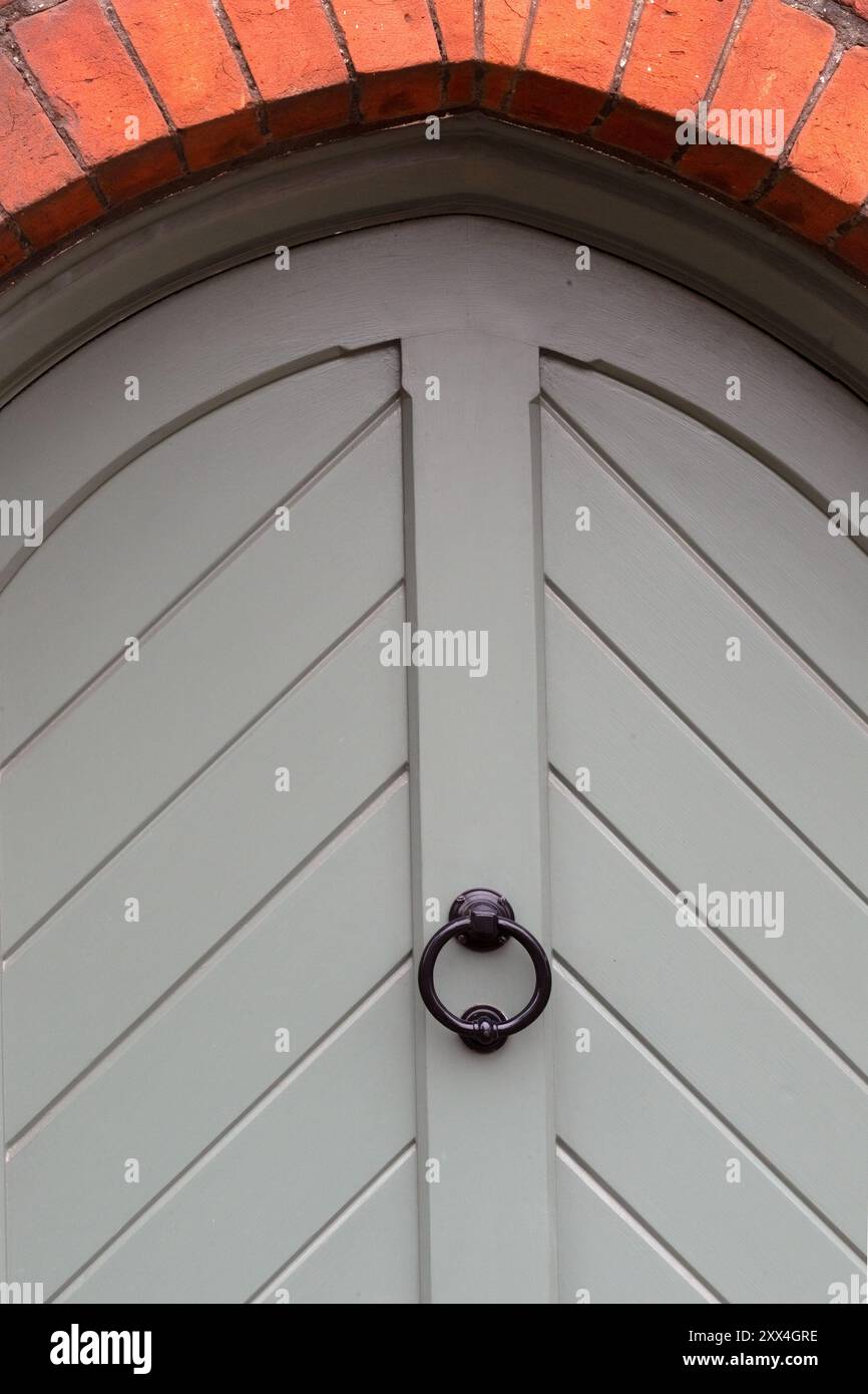 Porte arquée en bois gris et heurtoir de porte Banque D'Images