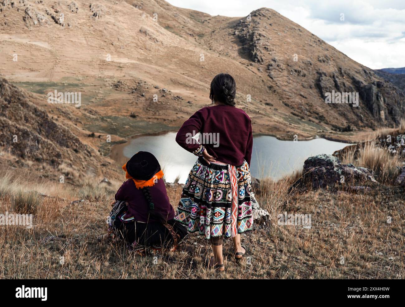 Deux femmes quechua en vêtements traditionnels regardant un lac dans les Andes, Vallée sacrée, Pérou Banque D'Images